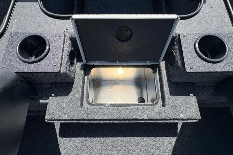 Slide: The Image of 2027 Tracker Pro Team 175 boat interior storage compartment with open lid and cup holders. - 16