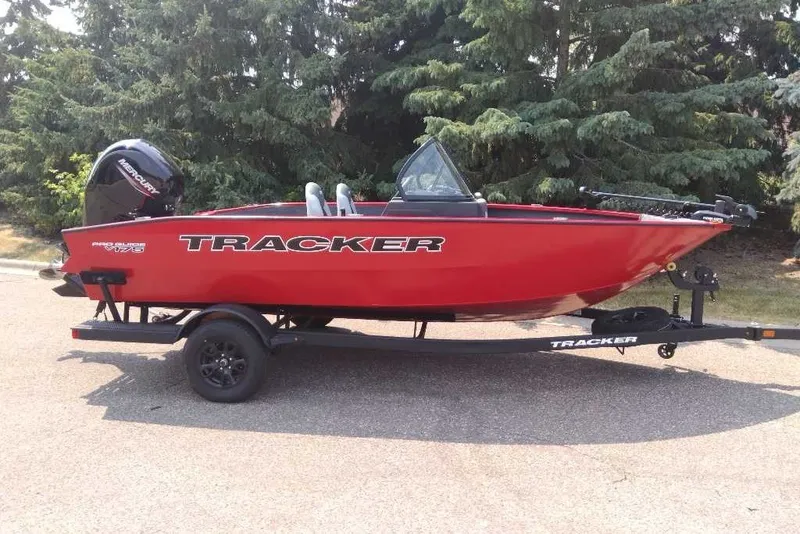 The Image of Red 2027 Tracker Pro Guide V-175 Combo boat on trailer, parked outdoors. - 0
