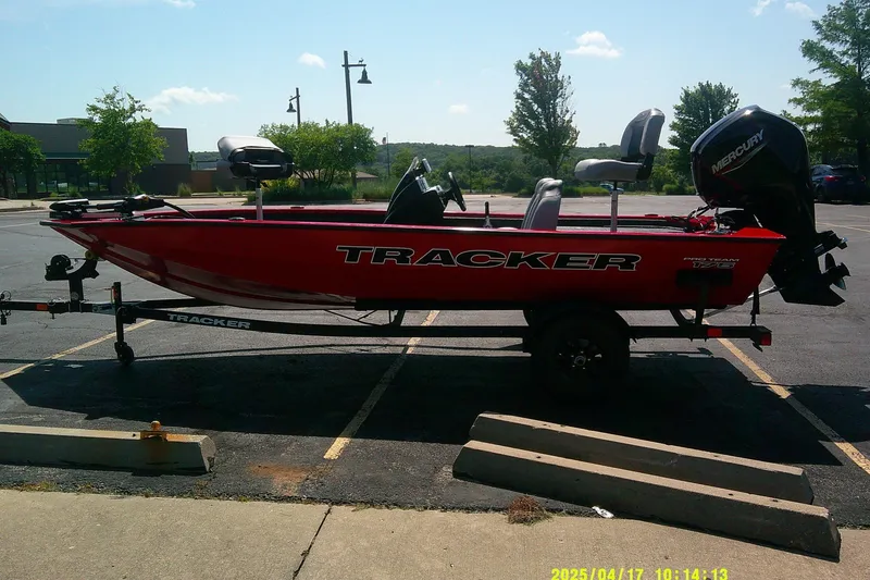 The Image of Red 2027 Tracker Pro Team 175 boat on trailer in parking lot. - 0