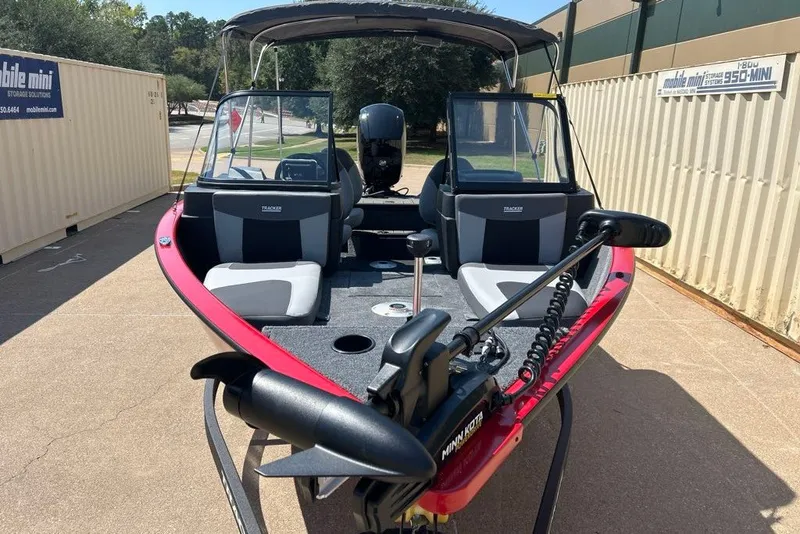 Slide: The Image of 2027 Tracker Pro Guide V-175 Combo boat with red exterior, parked outdoors. - 14