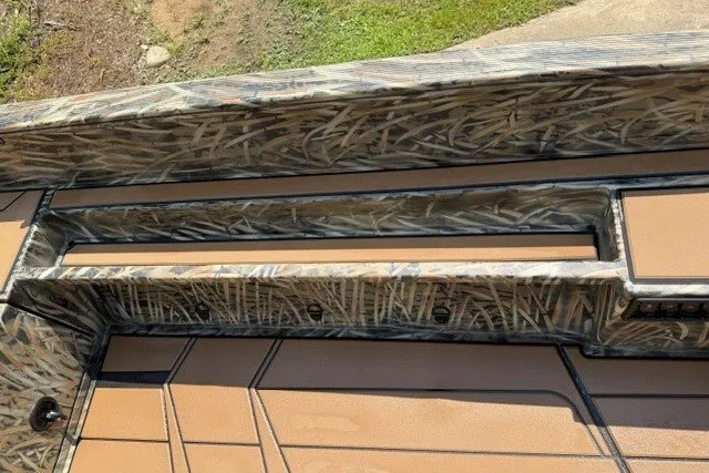 Slide: The Image of 2027 Tracker Grizzly 1553 Timber boat interior with camouflage design and tan flooring. - 13
