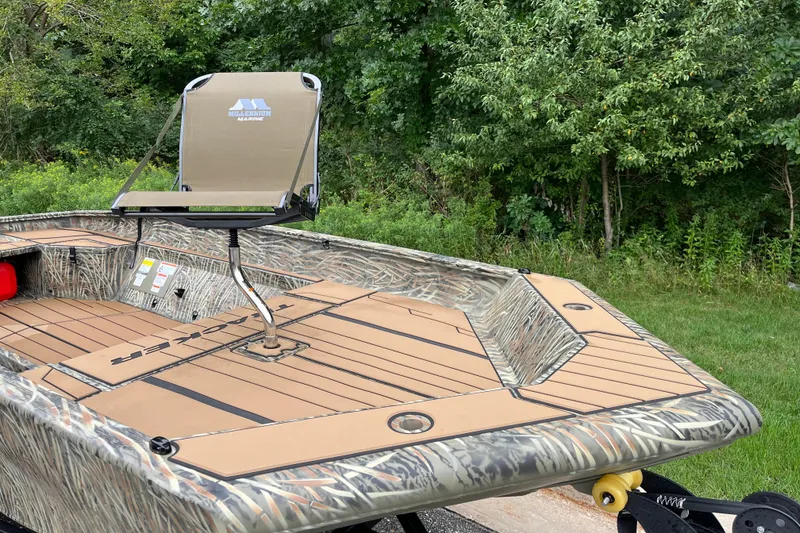 Slide: The Image of 2027 Tracker Grizzly 1553 Timber boat with camo design and elevated seat, surrounded by greenery. - 14