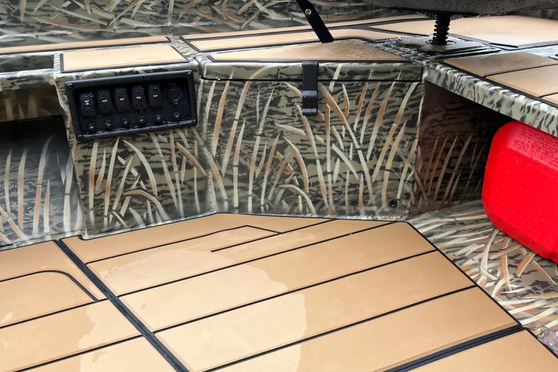 Slide: The Image of Interior of 2027 Tracker Grizzly 1553 Timber boat with camo design and control panel. - 28