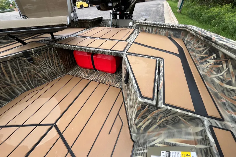 Slide: The Image of 2027 Tracker Grizzly 1553 Timber boat interior with camo design and red storage compartment. - 26