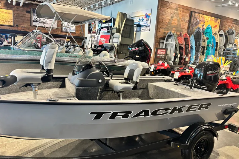 The Image of 2027 Tracker Super Guide V-16 SC boat displayed in a showroom with Mercury engine. - 0