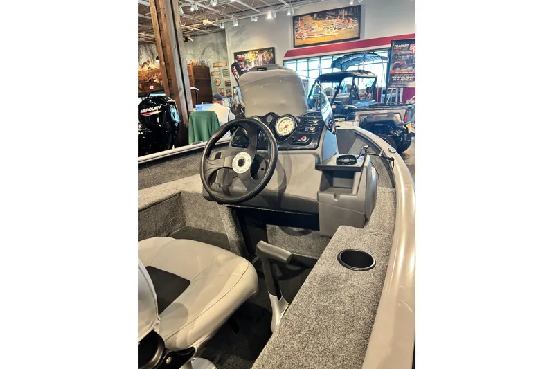 Slide: The Image of Interior view of 2027 Tracker Super Guide V-16 SC boat, showcasing steering console and seating. - 13