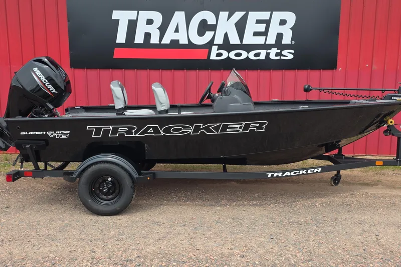 The Image of 2027 Tracker Super Guide V-16 SC boat displayed outside dealership. - 0