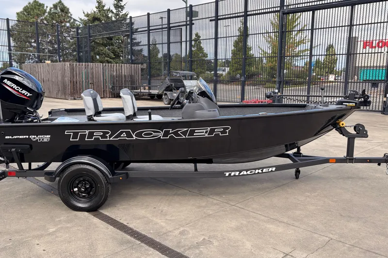 The Image of 2027 Tracker Super Guide V-16 SC boat on trailer, parked outdoors. - 0