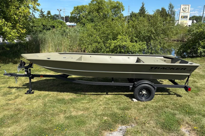 The Image of 2027 Tracker Grizzly 1648 Utility boat on trailer, parked on grassy area. - 0