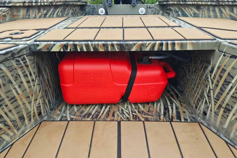 Slide: The Image of 2027 Tracker Grizzly 1553 Timber boat with red fuel tank in camo storage compartment. - 18