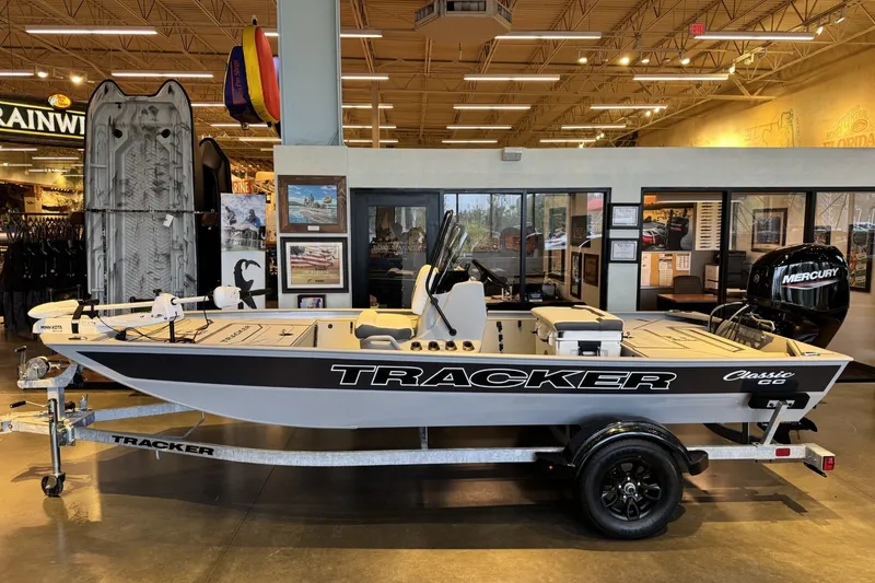 The Image of 2027 Tracker Bass Tracker Classic CC boat displayed indoors on a trailer. - 0