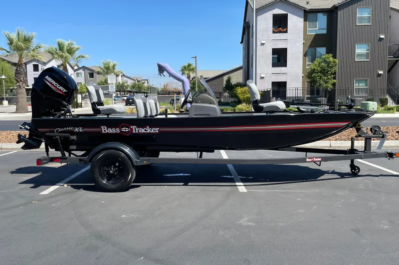 The Image of 2027 Tracker Bass Tracker Classic XL boat parked in a lot, featuring a Mercury engine. - 0