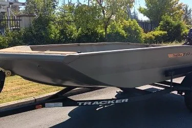 The Image of 2027 Tracker Grizzly 1553 Timber boat on trailer, parked outdoors. - 0