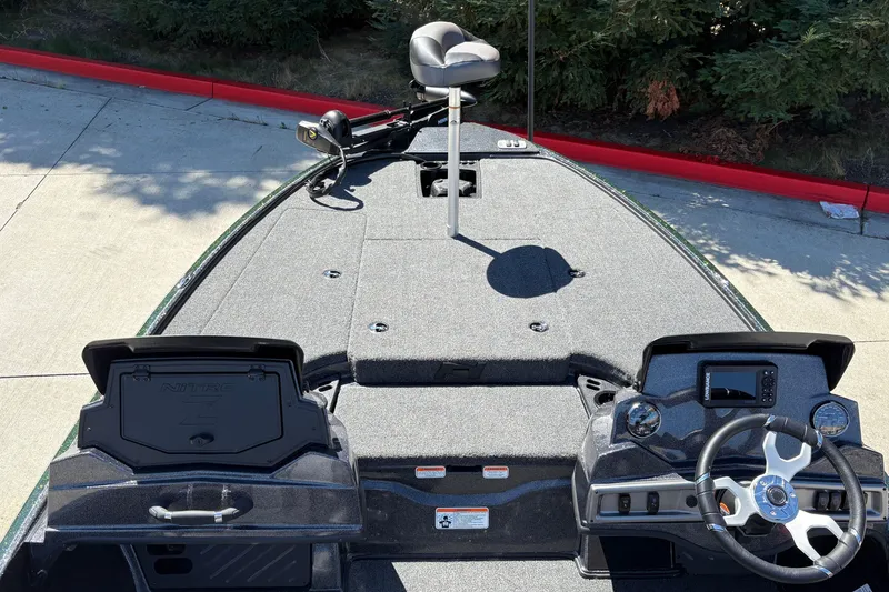 Slide: The Image of 2027 Nitro Z18 XL boat interior with steering wheel and seating, parked on concrete. - 32