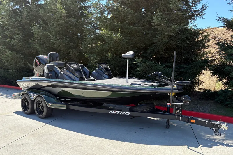 Slide: The Image of 2027 Nitro Z18 XL boat on trailer, parked outdoors near trees. - 2