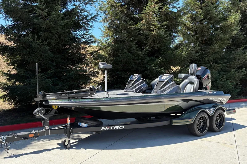 Slide: The Image of 2027 Nitro Z18 XL fishing boat on trailer, parked outdoors near trees. - 9