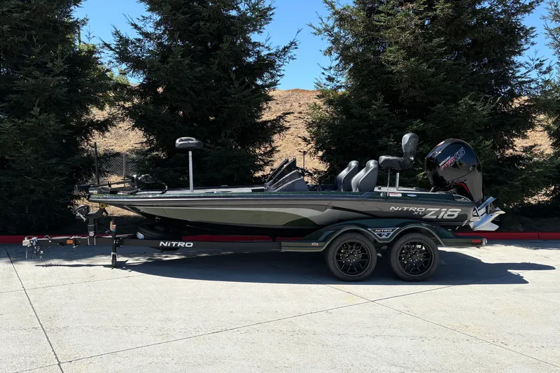 Slide: The Image of 2027 Nitro Z18 XL boat on trailer, parked outdoors with trees in background. - 1