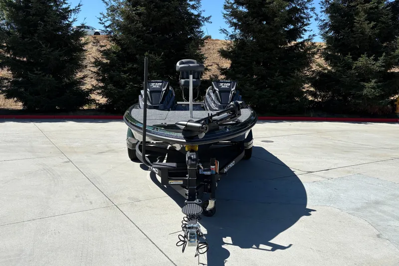 Slide: The Image of 2027 Nitro Z18 XL boat parked on concrete, surrounded by trees. - 14
