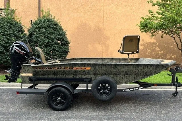 The Image of 2027 Tracker Grizzly 1553 Timber boat on trailer, featuring a Mercury outboard motor. - 0