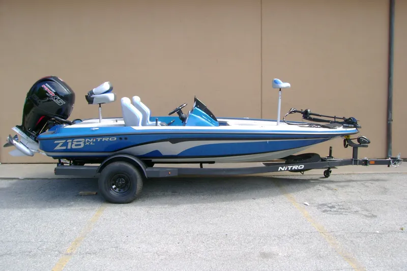 The Image of 2027 Nitro Z18 XL boat on trailer, blue and white design, parked outdoors. - 0