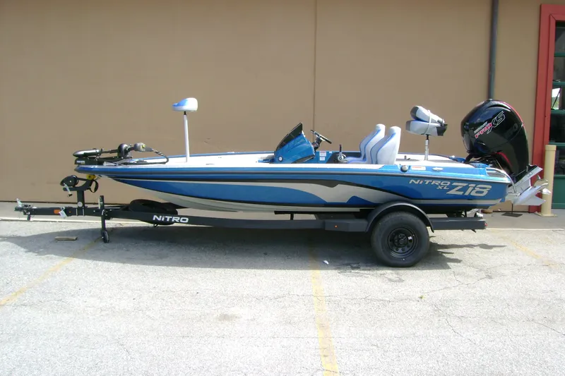 Slide: The Image of 2027 Nitro Z18 XL boat in blue, parked on a trailer, side view. - 1