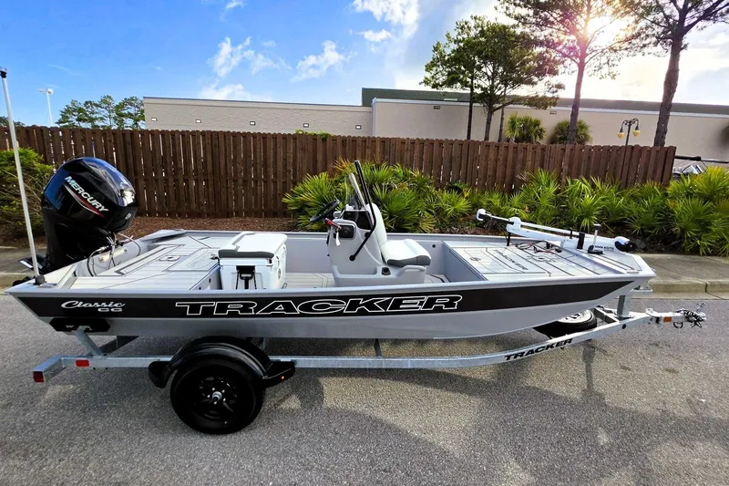 The Image of 2027 Tracker Bass Tracker Classic CC boat on trailer, parked outdoors under sunny sky. - 0