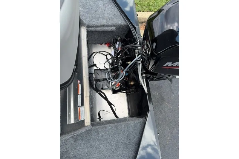 Slide: The Image of 2027 Tracker Bass Tracker Classic XL boat engine compartment with wiring and motor components. - 17