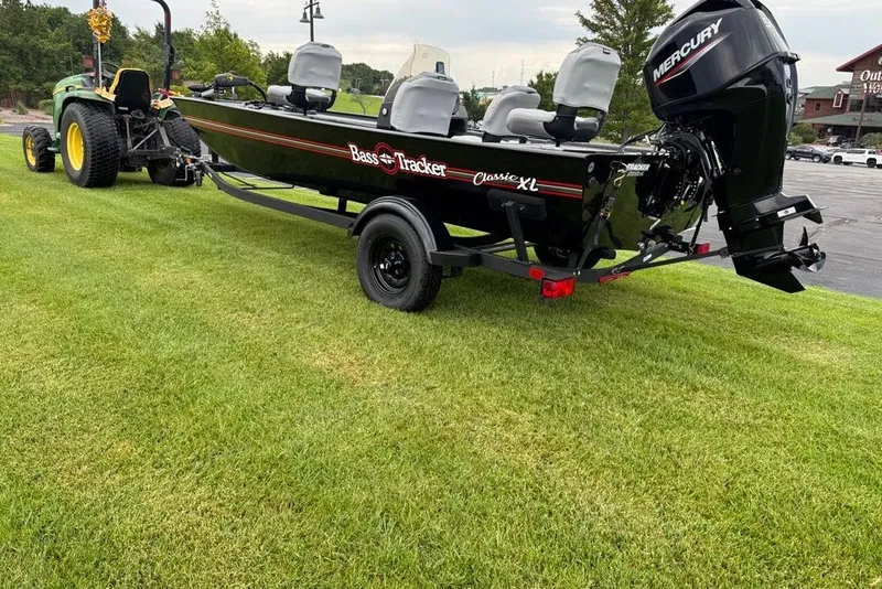 The Image of 2027 Tracker Bass Tracker Classic XL boat on trailer, hitched to a tractor. - 0