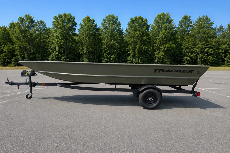 The Image of 2027 Tracker Grizzly 1648 Utility boat on trailer, parked in lot with trees. - 0