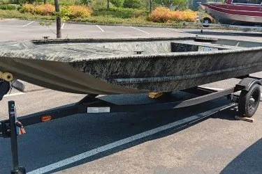 The Image of 2027 Tracker Grizzly 1648 Utility boat on trailer in parking lot. - 0