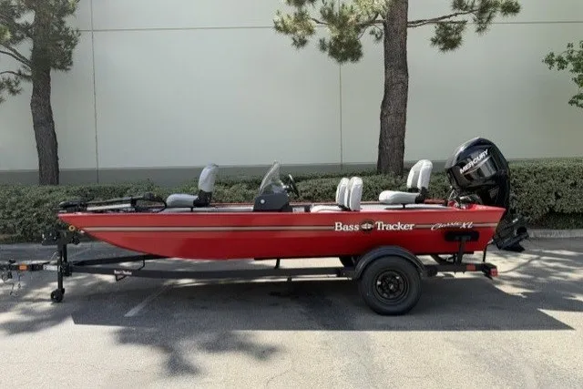 The Image of 2027 Tracker Bass Tracker Classic XL boat on trailer, parked outdoors. - 0