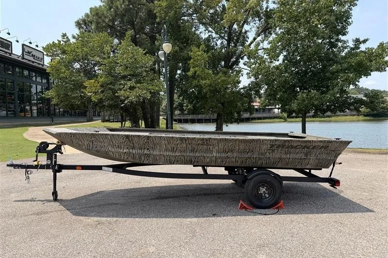The Image of 2027 Tracker Grizzly 1648 Utility boat on trailer by a lake. - 0
