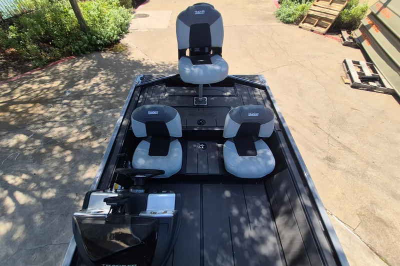 Slide: The Image of 2027 Tracker Pro 170 boat interior with three seats, steering console, and outdoor setting. - 13