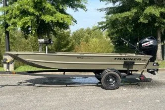 The Image of 2027 Tracker Grizzly 1654 T Sportsman boat on trailer, parked outdoors. - 0