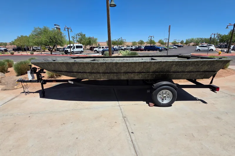 The Image of 2027 Tracker Grizzly 1648 Utility boat on trailer in parking lot. - 0