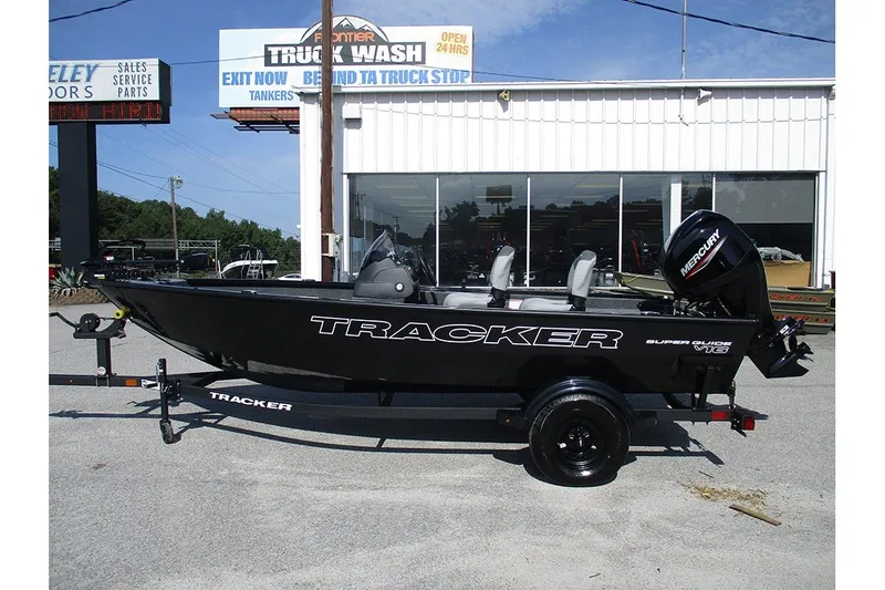 The Image of 2027 Tracker Super Guide V-16 SC boat on trailer outside dealership. - 1