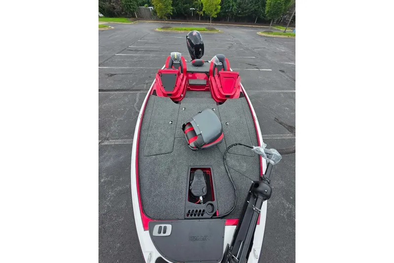 Slide: The Image of 2027 Nitro Z18 XL boat with red and gray interior in a parking lot. - 9