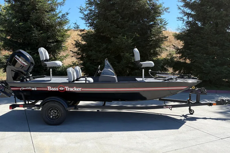The Image of 2027 Tracker Bass Tracker Classic XL boat on trailer, parked outdoors. - 0