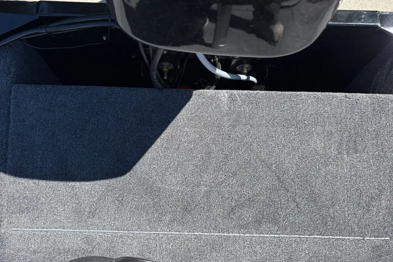 Slide: The Image of Interior view of 2027 Tracker Bass Tracker Classic XL boat, showcasing carpeted flooring and engine compartment. - 26