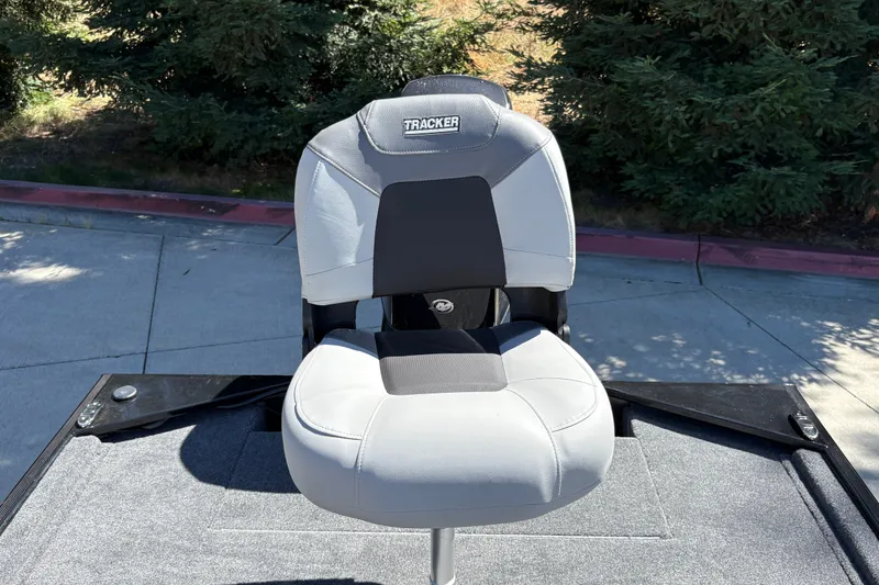 Slide: The Image of 2027 Tracker Bass Tracker Classic XL boat seat on deck, surrounded by greenery. - 22