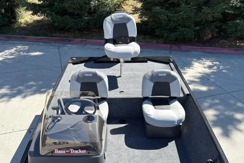 Slide: The Image of 2027 Tracker Bass Tracker Classic XL boat with three seats, parked outdoors. - 15