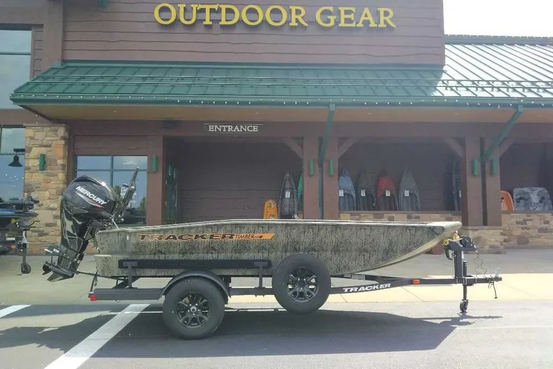 The Image of 2027 Tracker Grizzly 1553 Timber boat on trailer outside outdoor gear store. - 0