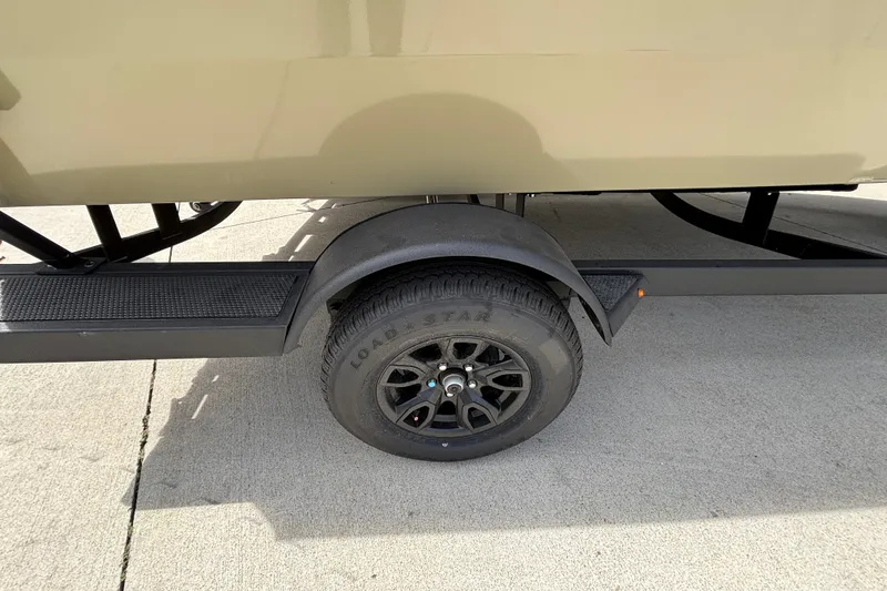 Slide: The Image of Trailer wheel of 2027 Tracker Pro Guide V-175 Combo boat on pavement. - 14
