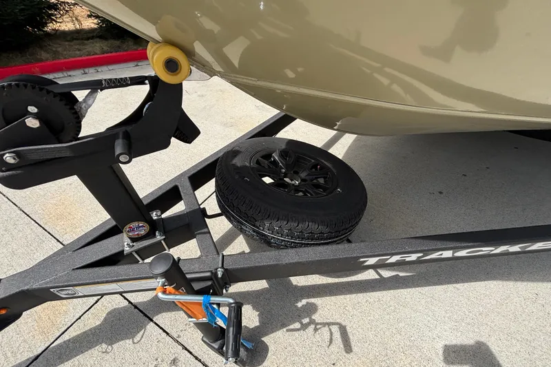 Slide: The Image of Trailer for 2027 Tracker Pro Guide V-175 Combo with spare tire on concrete surface. - 16