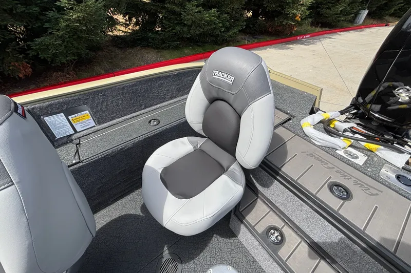 Slide: The Image of 2027 Tracker Pro Guide V-175 Combo boat seat, gray and black design, outdoor setting. - 24