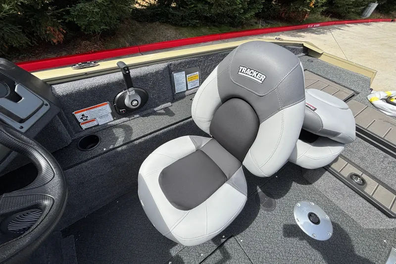 Slide: The Image of 2027 Tracker Pro Guide V-175 Combo boat seat, gray and white design, cockpit view. - 25