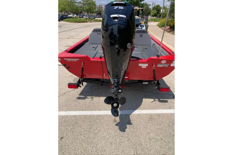 Slide: The Image of Red 2027 Tracker Pro Team 175 boat with Mercury outboard motor in parking lot. - 23