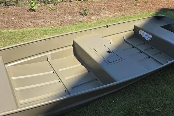 Slide: The Image of 2027 Tracker Grizzly 15 Jon boat on grass, showcasing spacious interior and durable design. - 25