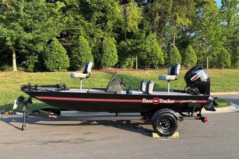 The Image of 2027 Tracker Bass Tracker Classic XL boat on trailer, parked outdoors. - 0