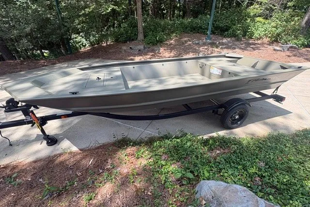 The Image of 2027 Tracker Grizzly 1648 Utility boat on trailer, parked outdoors. - 0
